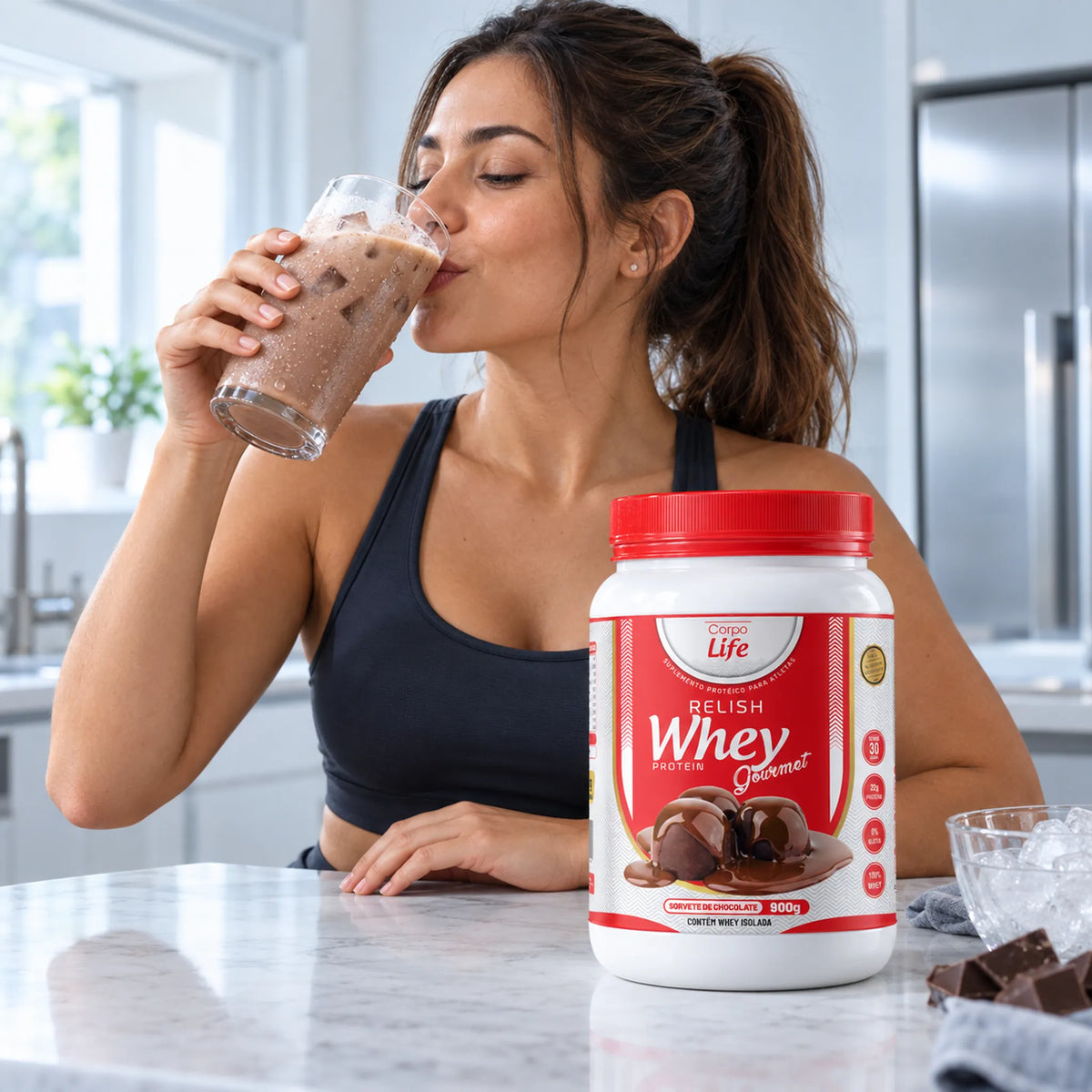 Pessoa com roupa de treino bebendo shake de chocolate gelado ao lado do pote de Relish Whey
